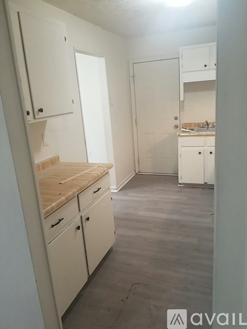 A kitchen with white cabinets and a wooden countertop.