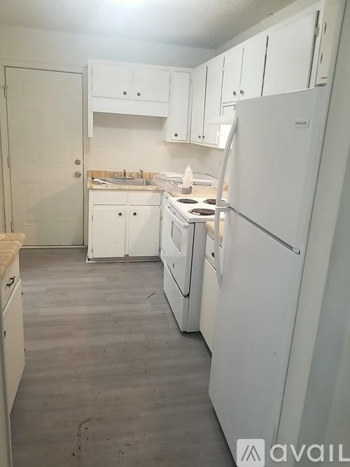 A kitchen with white appliances and cabinets.