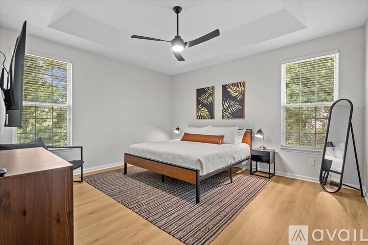 A bedroom with a bed, a ceiling fan, and a window with blinds.