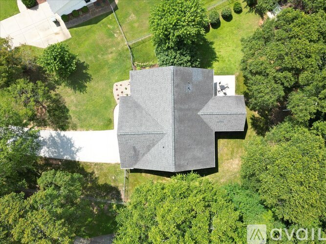 A house with a grey roof surrounded by trees.