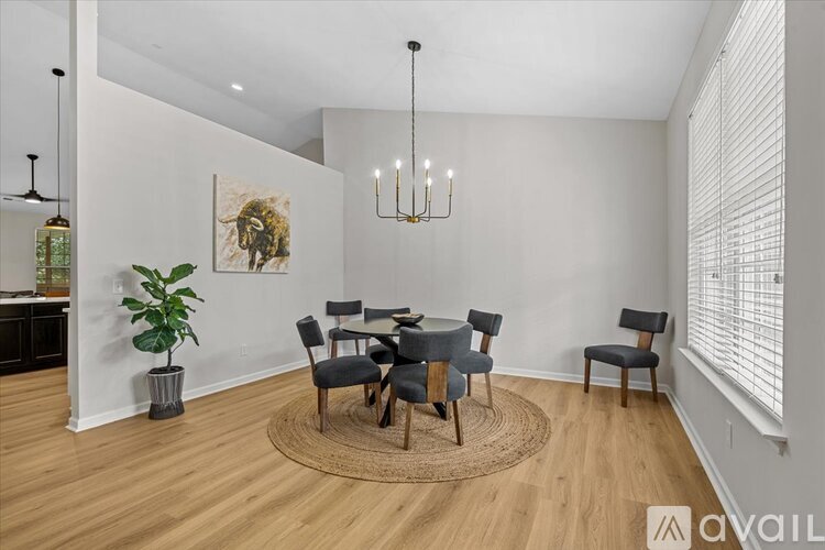 A dining room with a round table and chairs.