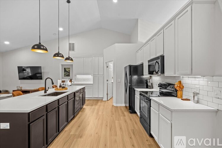 A modern kitchen with dark brown cabinets and white countertops.
