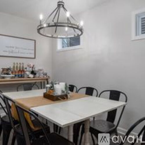 A dining room with a white table and chairs.