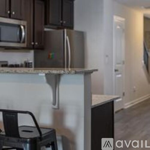 A kitchen with a microwave, oven, and a black trash can.