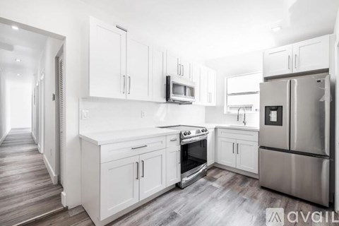 A kitchen with white cabinets and stainless steel appliances.