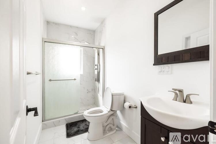 A bathroom with a toilet, sink, and mirror.