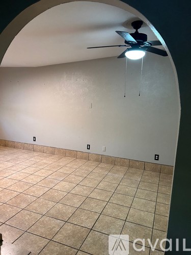 A room with a ceiling fan and a tiled floor.