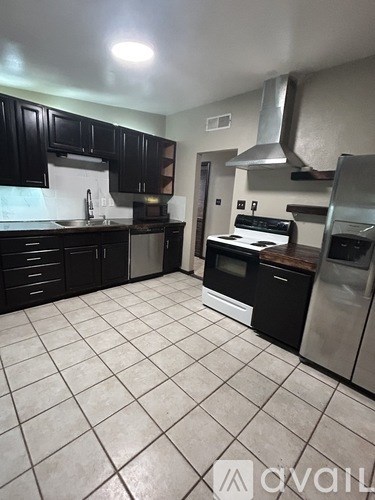 A kitchen with black cabinets and white appliances.
