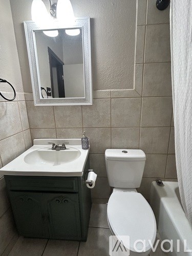 A bathroom with a white toilet and a sink with a cabinet below it.