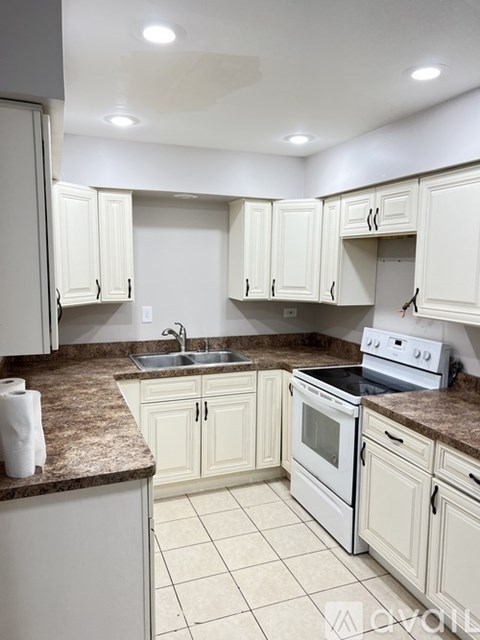 A kitchen with white cabinets and a granite countertop.
