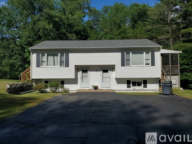 A two-story house with a garage and a driveway in front.