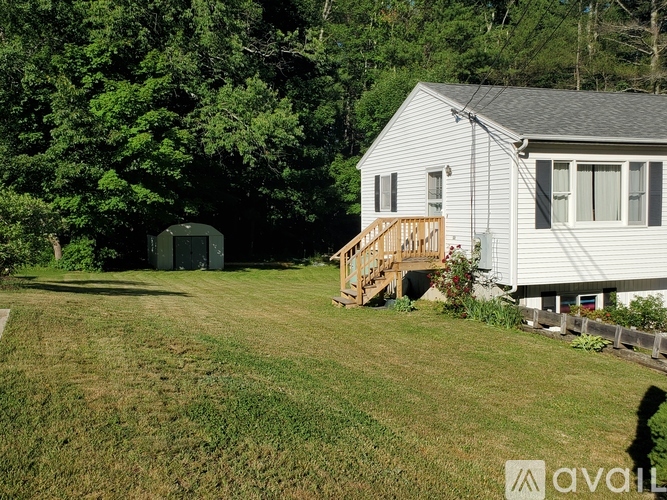 A house with a deck and a shed in the backyard.