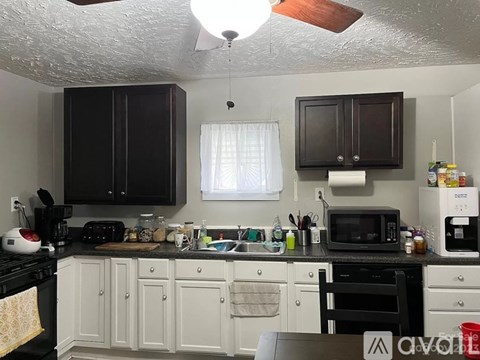 A kitchen with black and white cabinets and appliances.