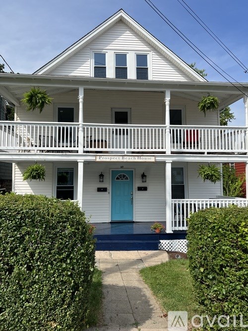 A white house with a blue door and a sign that says "Pleasure Garden".