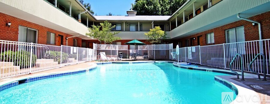 A swimming pool surrounded by a fence and a building in the background.