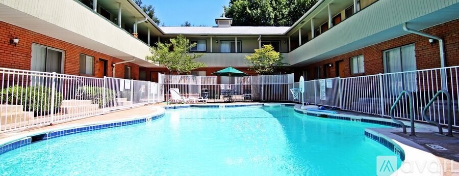 A swimming pool surrounded by a fence and a building in the background.