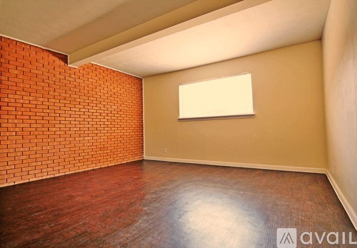 A room with a brick wall and wooden floor.