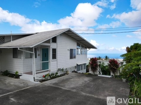 A house with a white exterior and a blue door is for sale.