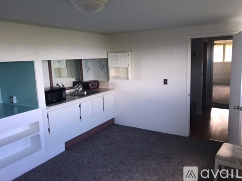 A kitchen with white cabinets and a microwave on the counter.