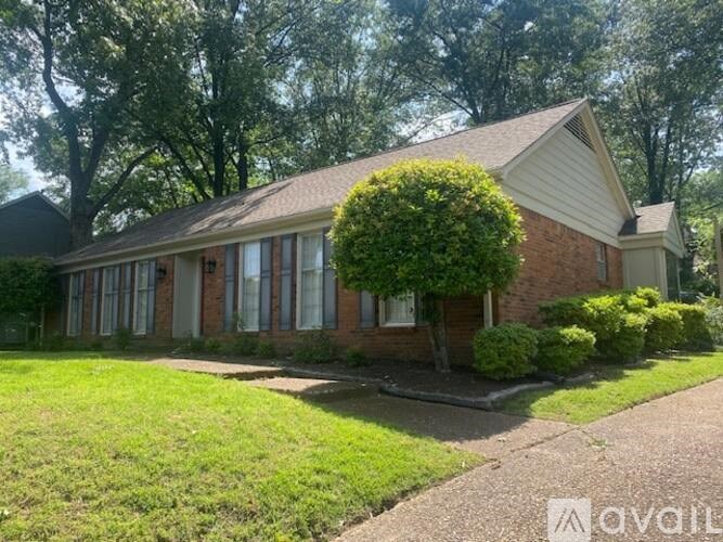 A house with a well-maintained lawn and a driveway in front.