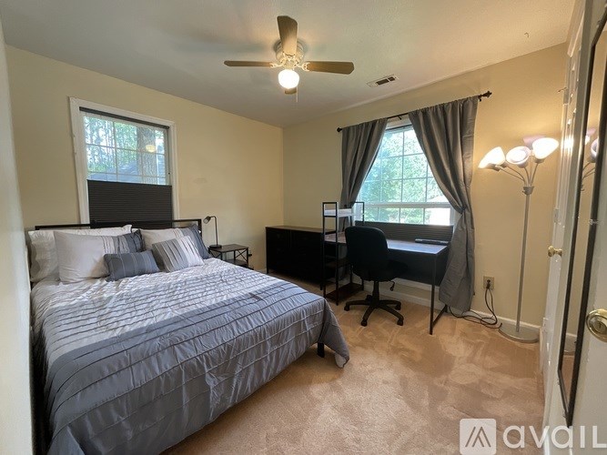 A bedroom with a bed, desk, and chair.