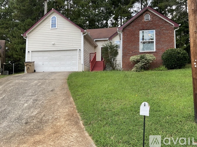 A house with a garage and a driveway in front of it.