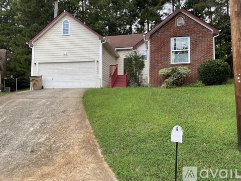 A house with a garage and a driveway in front of it.