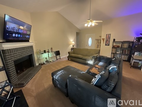 A living room with a fireplace and a television on the wall.