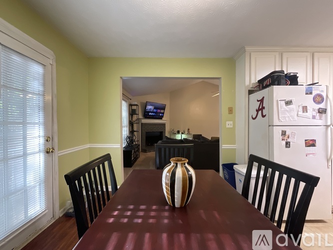 A dining room with a brown table and a vase on it.
