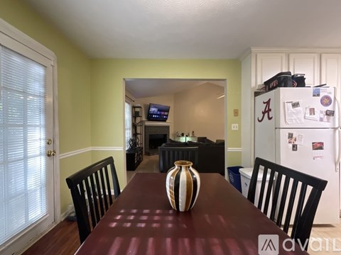 A dining room with a brown table and a vase on it.