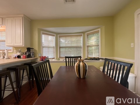 A kitchen with a table and chairs in front of a window.