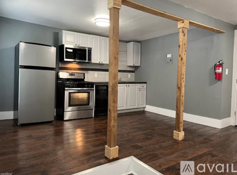 A kitchen with a refrigerator, oven, and cabinets.