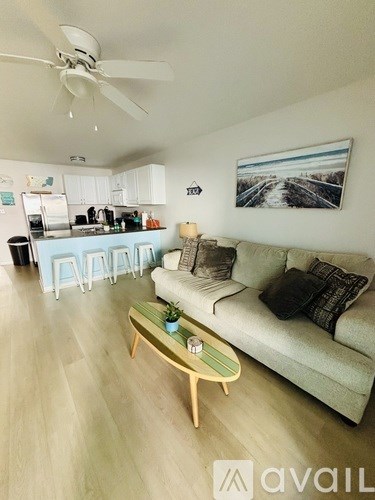 A living room with a couch, a coffee table, and a painting on the wall.