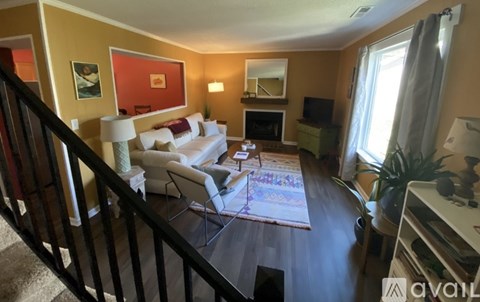 A living room with a white couch and a fireplace.