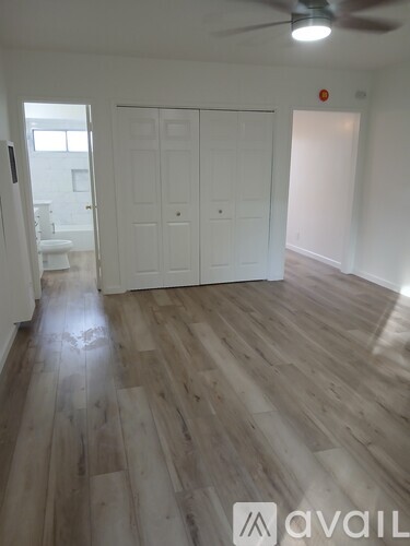 A room with a wooden floor and a ceiling fan.