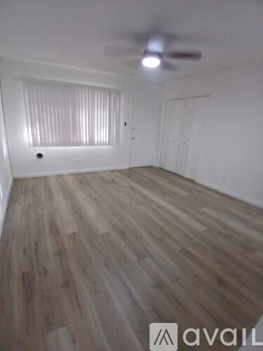 A room with wooden flooring and a ceiling fan.