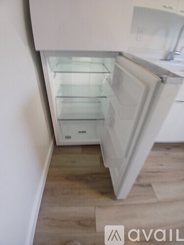 A white refrigerator with its door open in a kitchen.