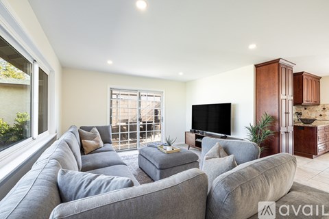 A living room with a grey sofa and a television.