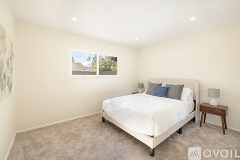 A bedroom with a large bed and a small table.