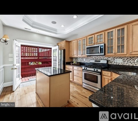 A kitchen with wooden cabinets and a black countertop.