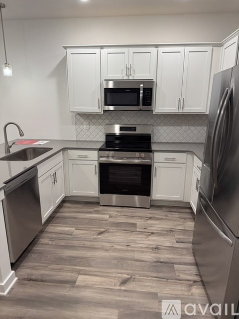A kitchen with white cabinets and stainless steel appliances.