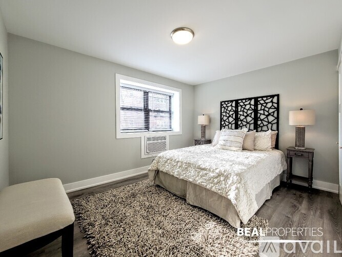 A bedroom with a bed, a chair, and a window.
