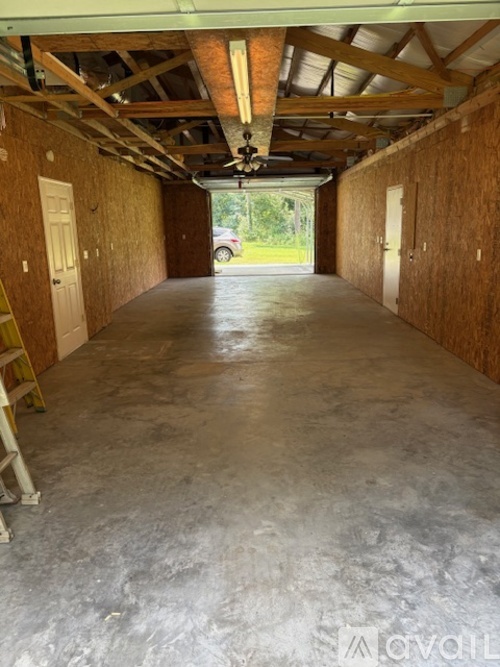 A large empty room with wooden walls and a concrete floor.