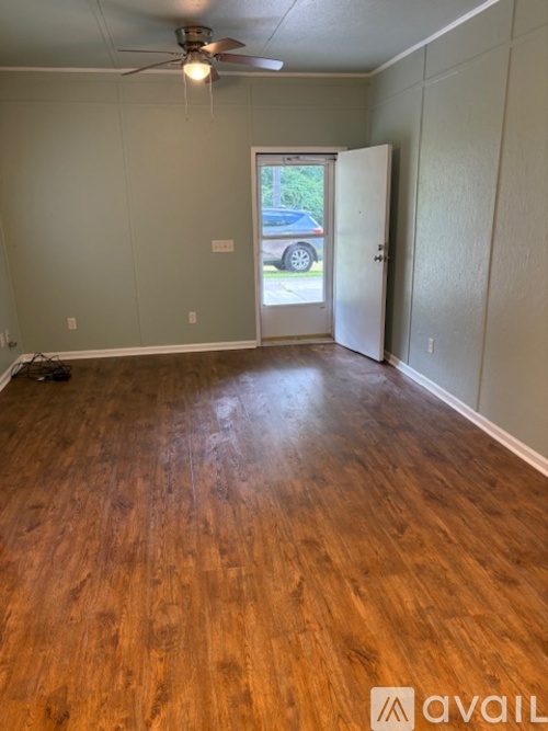 A room with wooden floors and a ceiling fan.