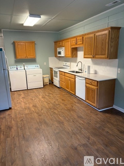 A kitchen with wooden cabinets and a white fridge.
