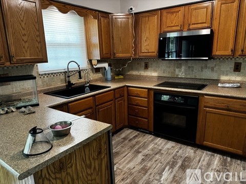 A kitchen with wooden cabinets and granite countertops.