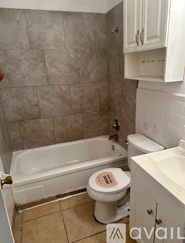 A bathroom with a toilet, tub, and sink.