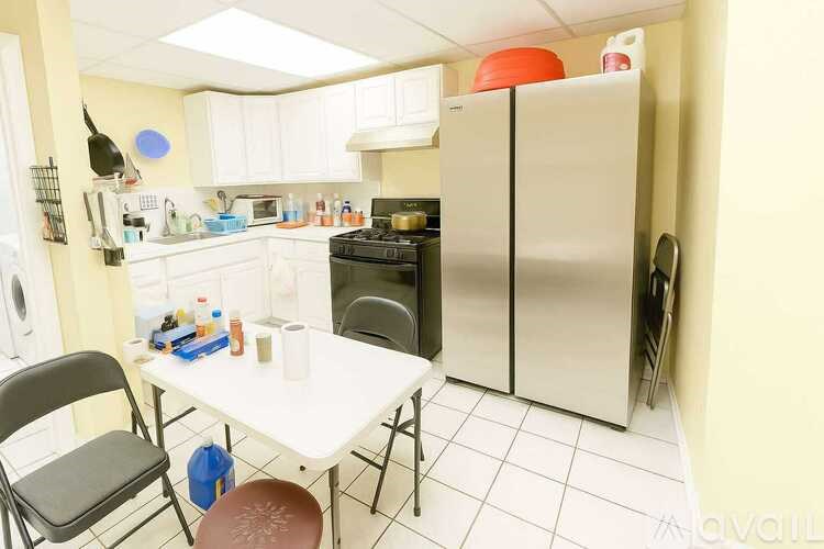 A kitchen with a table and chairs in front of a refrigerator.