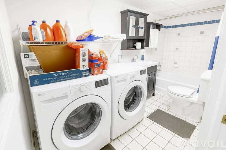 A small laundry room with a washer and dryer and a toilet.