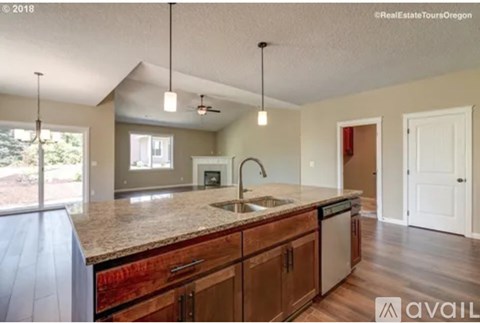 A kitchen with wooden cabinets and a granite countertop.
